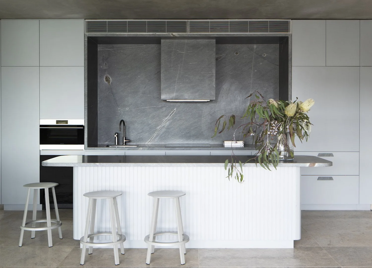 Soft grey and mint kitchen with white island bench featuring wolf appliances